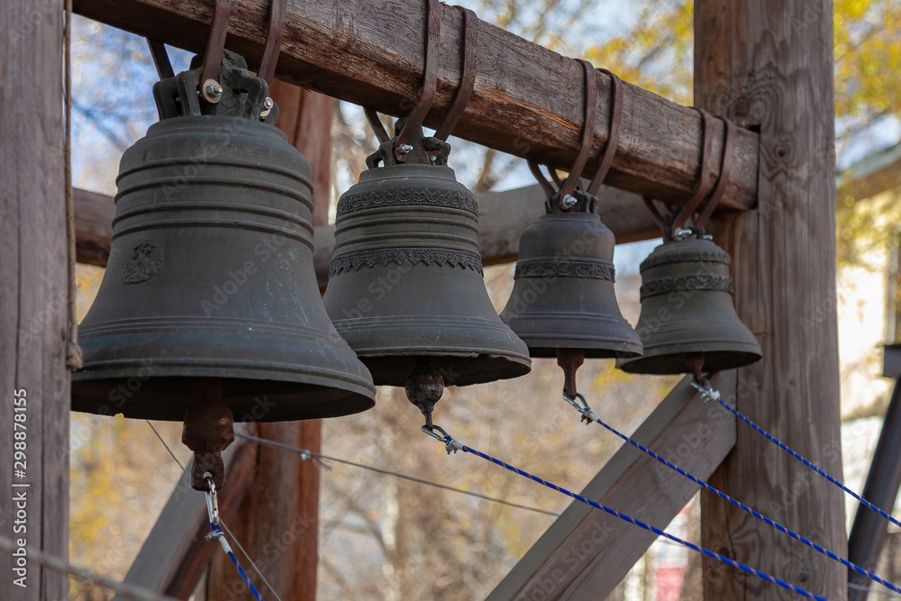 Four distant bronze church bells of different sizes