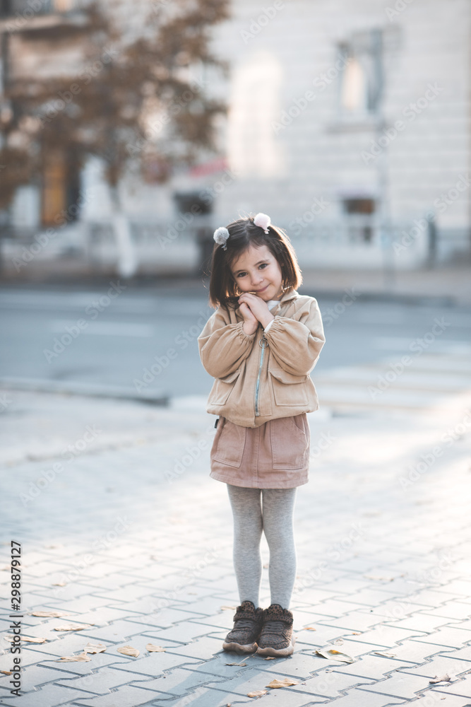 Cute kid girl 3-4 year old wearing trendy clothes posing in