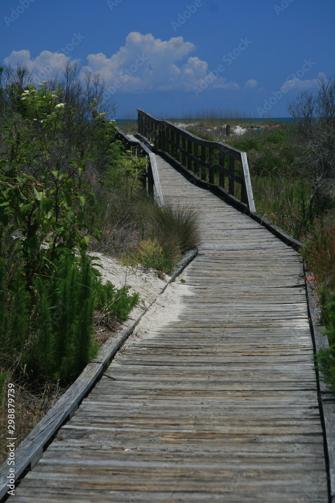 old wooden boardwalk path through beach dunes