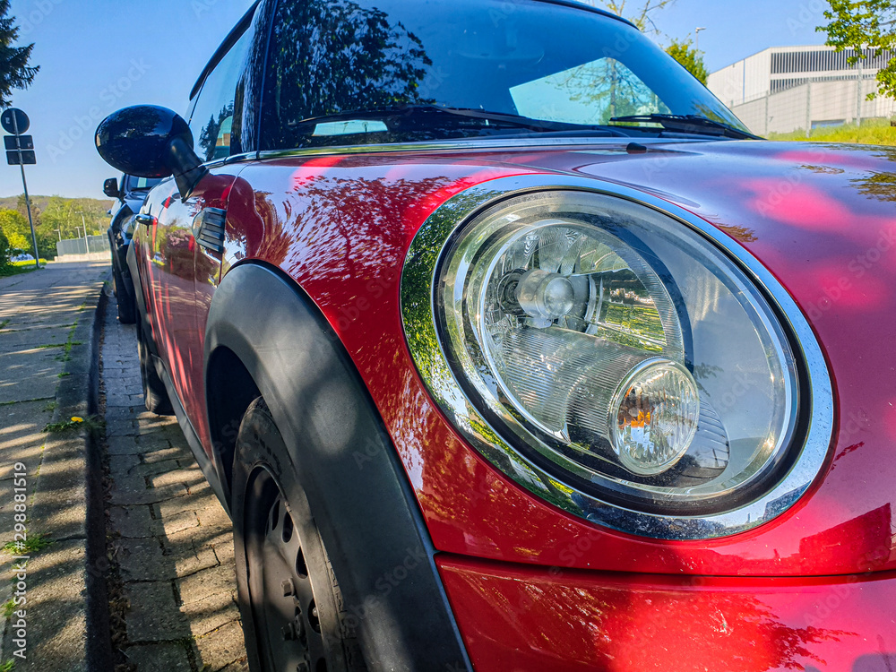 Fototapeta premium The front of the car is a close-up. Car headlight. red car