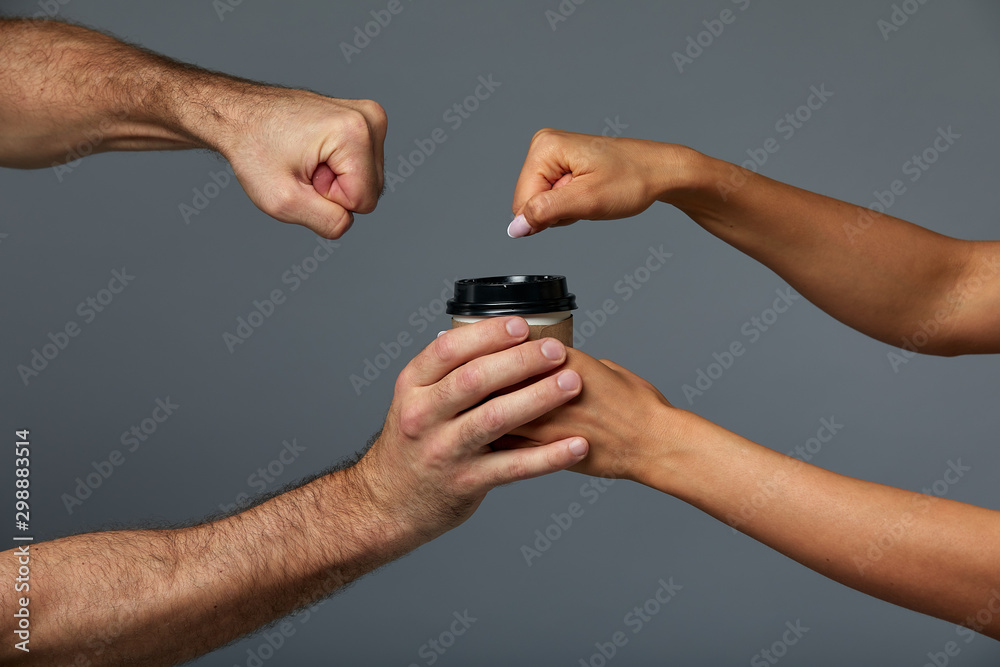 Female and male hand mock paper cup with tea or coffee drink, on isolate gray background. Gray background, copy space Female and male hand mock paper cup with tea or coffee drink, on isolate gray background. Gray background, copy space