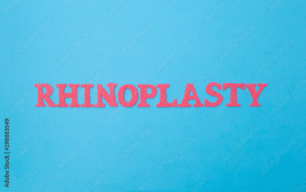 Rhinoplasty word in red letters on a blue background. The concept of the modern procedure for changing the correction and shape of the nose, rhinoplasty. Plastic surgery in medicine Rhinoplasty word in red letters on a blue background. The concept of the modern procedure for changing the correction and shape of the nose, rhinoplasty. Plastic surgery in medicine