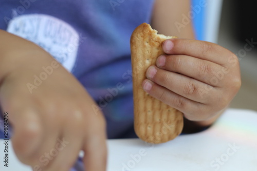 Criança segurando biscoito de maizena photo