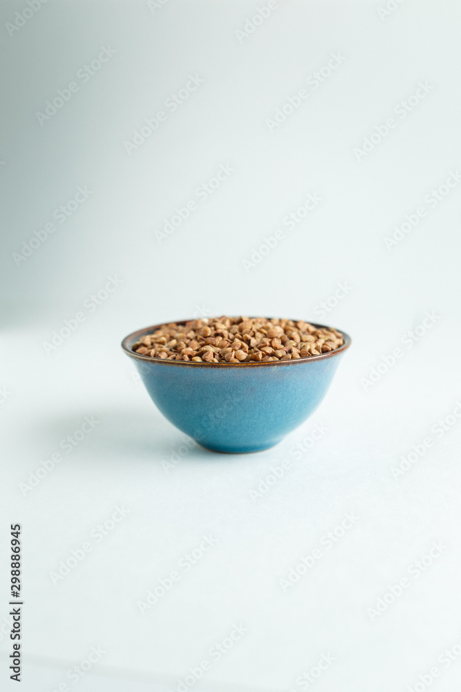 Buckwheat grains in a bowl on a white background isolate Buckwheat grains in a bowl on a white background isolate