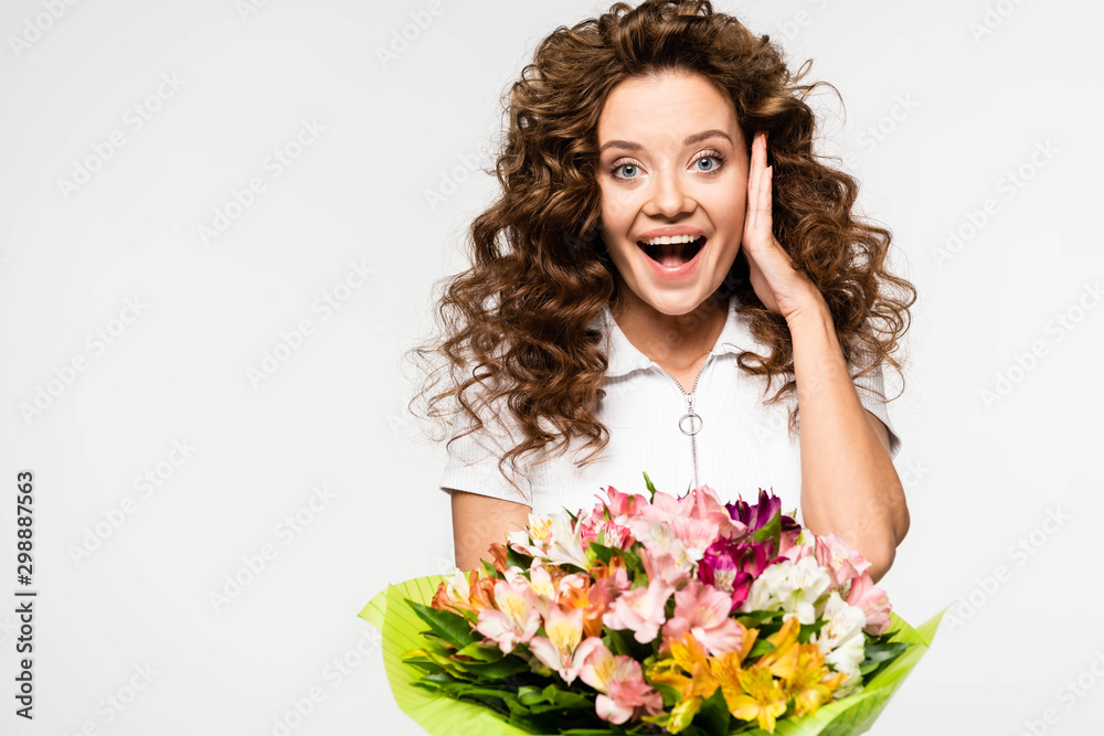 excited curly girl holding bouquet of flowers, isolated on white