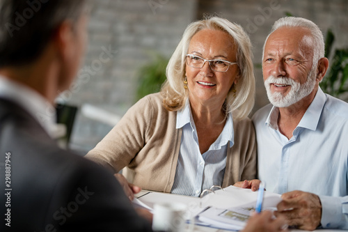 Happy senior couple having a meeting with real estate agent. photo
