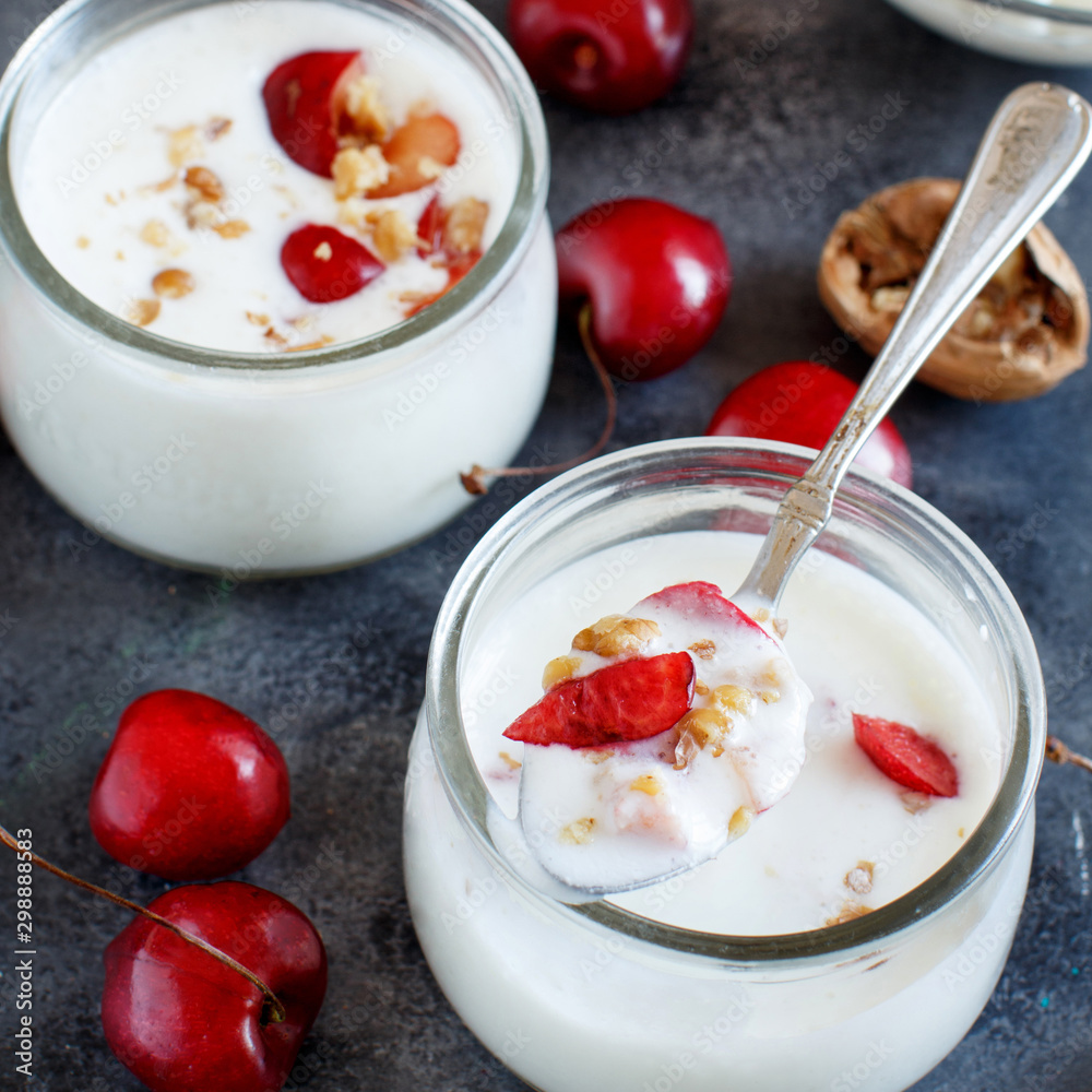 Fermented yogurt kefir in small bottles with cherries and walnuts Fermented yogurt kefir in small bottles with cherries and walnuts