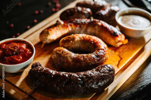 Oktoberfest food, appetizing meat sausages,. A large assortment on a wooden tray.