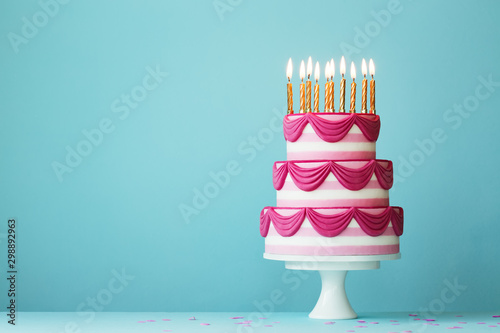 Fotografiet Tiered birthday cake with golden candles