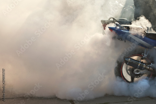 Wallpaper Mural The smoke comes out from under the wheels. Motorcycle wheel closeup. Smoke due to tire rubbing against asphalt. The rider prepares to do the trick on the motorcycle. Burned rubber on the road. Torontodigital.ca