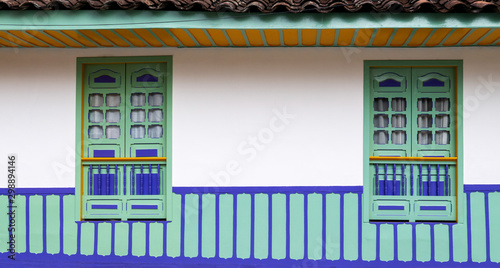 Traditional architecture of the coffee region, with two windows in green and violet colors and ceiling in yellow and green, in Filandia, Colombia photo