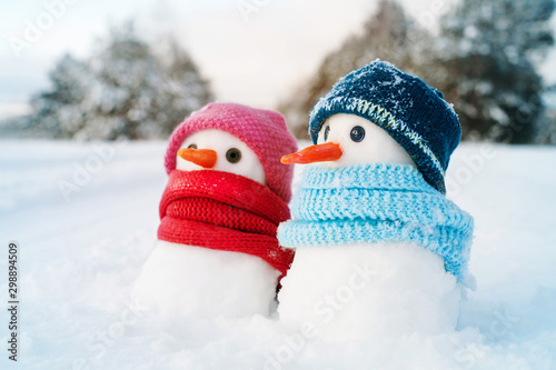 Two small snowmen the girl and the boy on snow, copy space. Greeting card for lovers, Christmas card © isavira