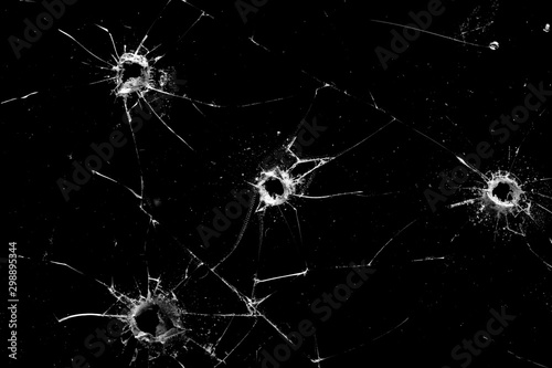 фотографія holes in the glass with cracks isolated on a black