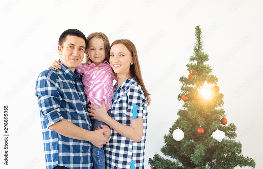 Holidays, gifts and christmas tree concept - Small family having happy time together on Christmas. Holidays, gifts and christmas tree concept - Small family having happy time together on Christmas.