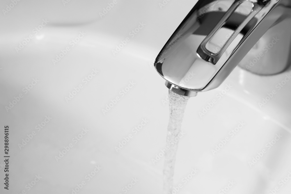 Closeup view of water flowing from faucet indoors. Space for text Closeup view of water flowing from faucet indoors. Space for text