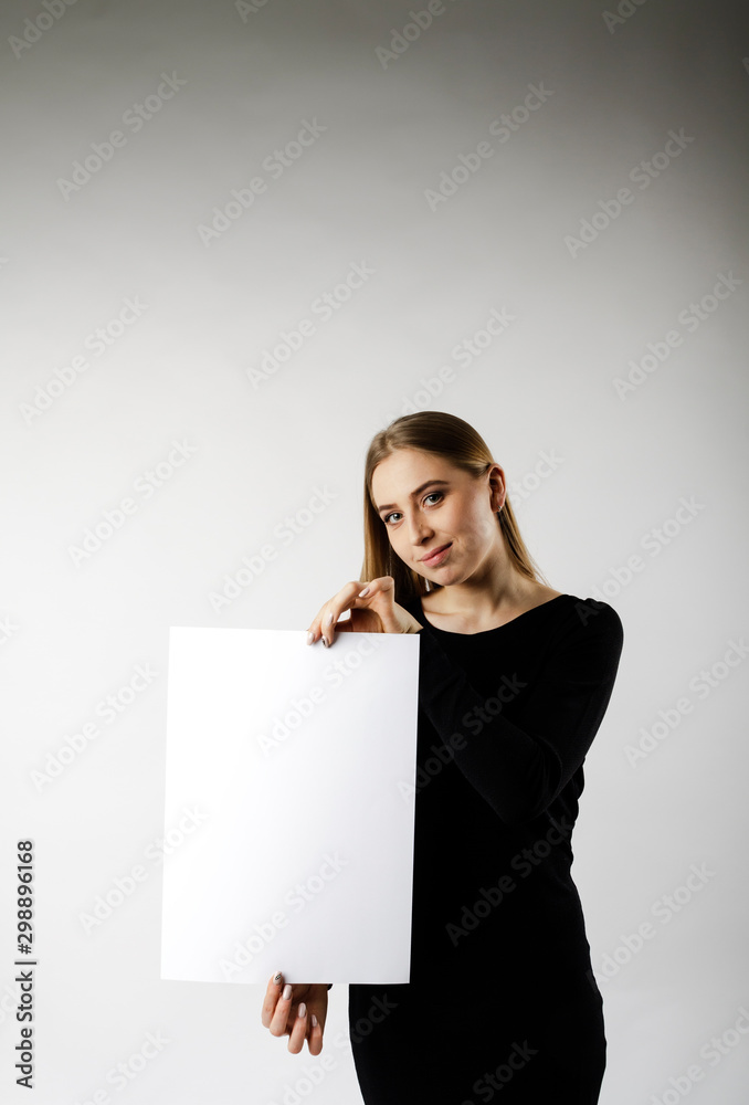 Young attractive woman is holding white paper. Young attractive woman is holding white paper.