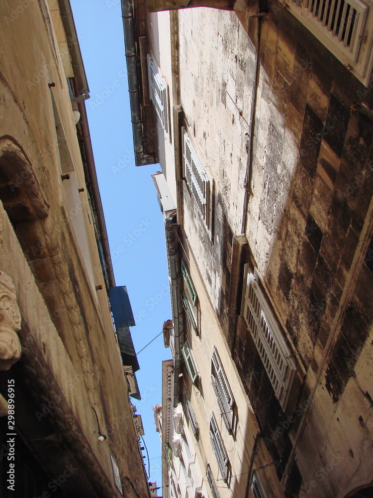 It's nice to walk through the cool dark narrow streets of the old town on a hot day, looking up at the sky. It's nice to walk through the cool dark narrow streets of the old town on a hot day, looking up at the sky.
