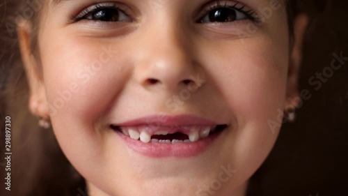 Portrait of a baby girl with a toothless smile. The child laughs hard. Show no teeth.