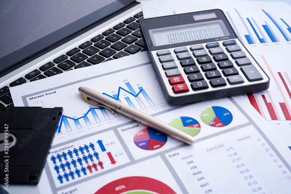 Business and finance with analytical study on market trend or demand with document on paper, calculator, laptop and a pen Business and finance with analytical study on market trend or demand with document on paper, calculator, laptop and a pen
