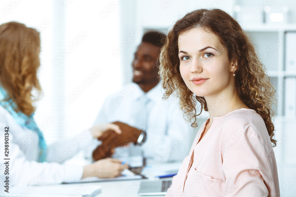 Fototapeta premium Business woman at meeting in office, colored in white. Multi ethnic business people group