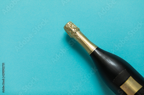 Champagne bottle on blue background. Flat lay. Party celebration concept