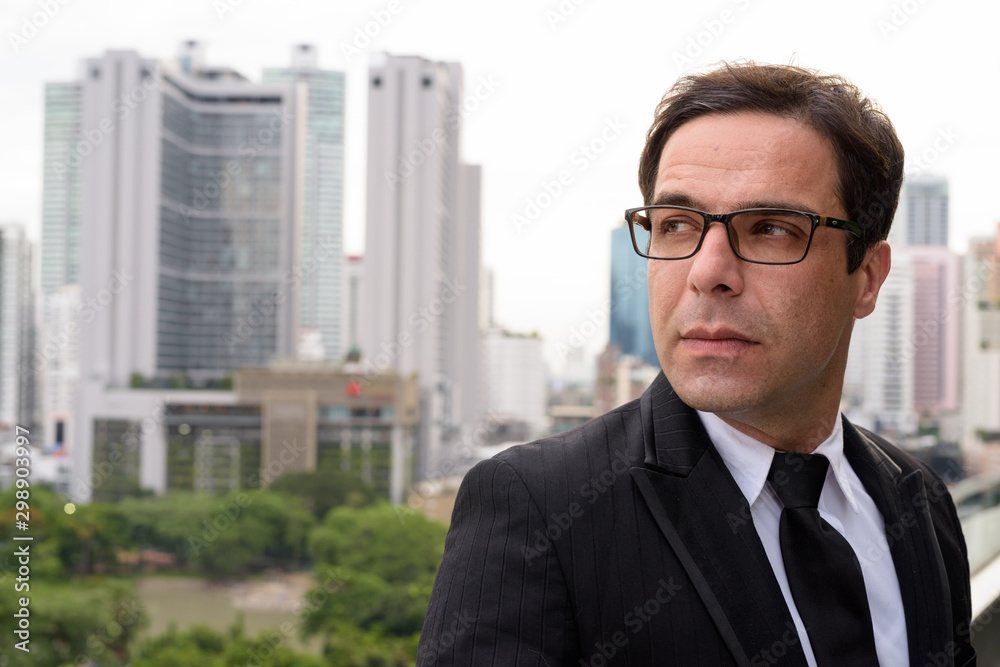 Handsome Persian businessman against view of the city Handsome Persian businessman against view of the city