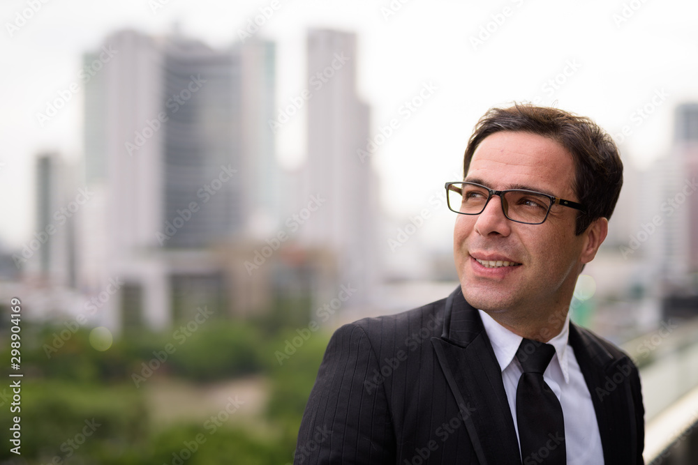 Handsome Persian businessman against view of the city Handsome Persian businessman against view of the city