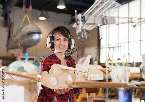Woman in pilot headsets having fun with plane model