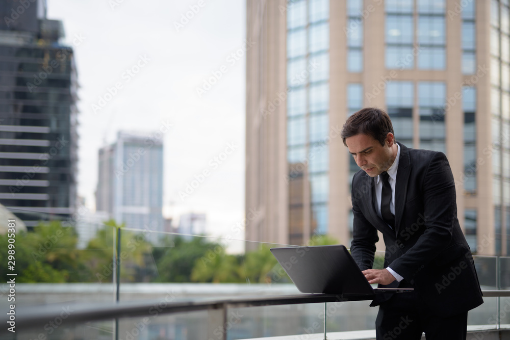 Handsome Persian businessman against view of the city Handsome Persian businessman against view of the city