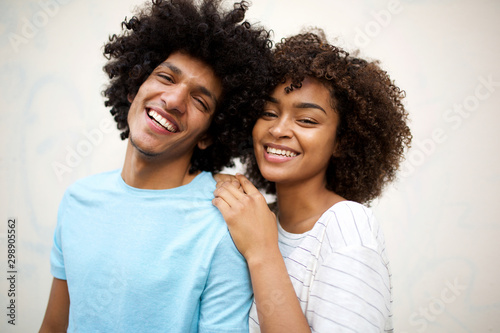 laughing afro man and smiling african american woman against white background photo