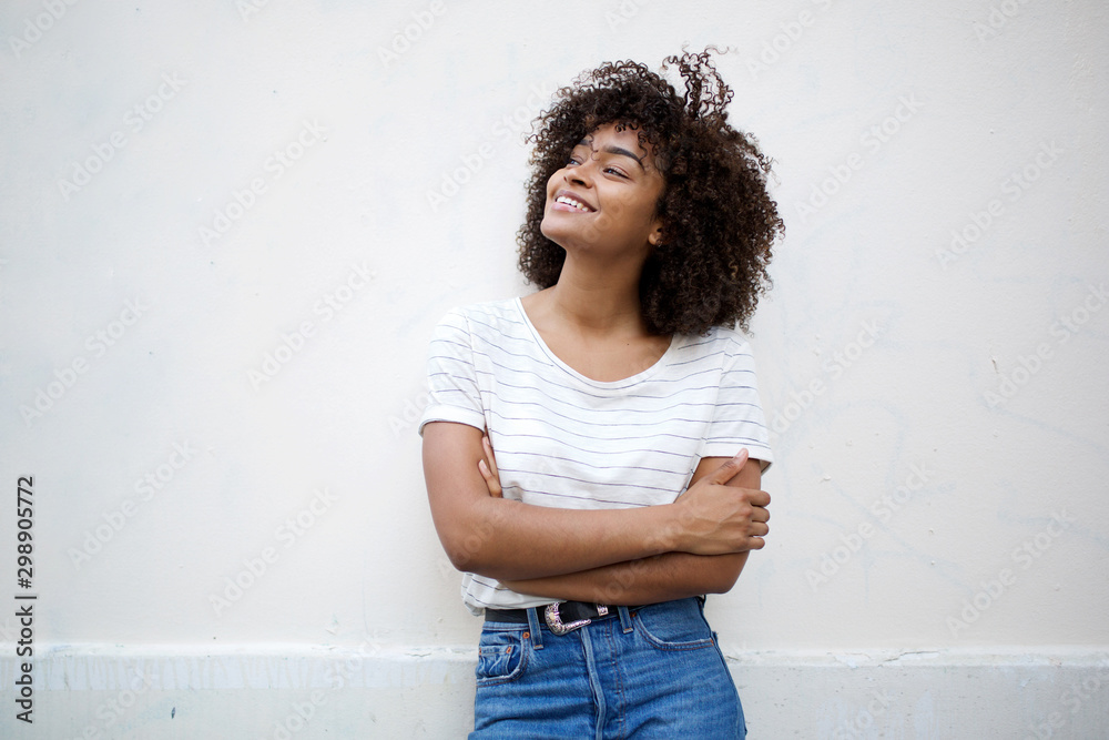 happy young african american woman smiling with arms crossed and looking away against white background - obrazy, fototapety, plakaty 