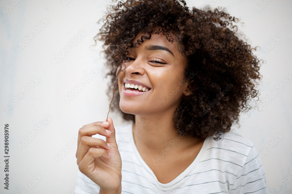 © mimagephotos - beautiful smiling young african american woman pulling hair