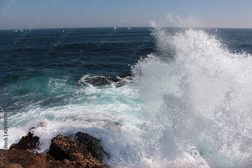 Movement on the shore. A view of sea waves bursting on the rocks and forming foam in Algarrobo beach in Chile