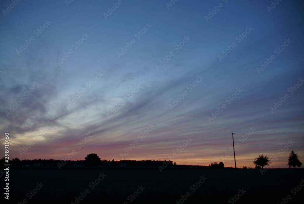 Abendliche Cirrostratus-Wolken über ländlicher Silhouette