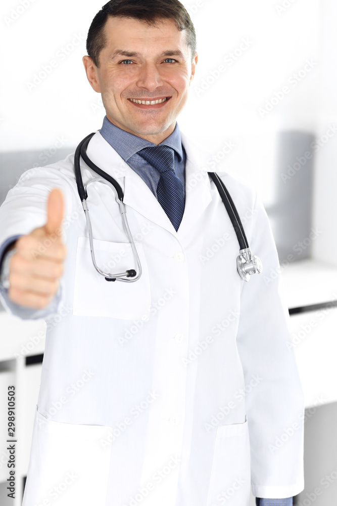 Doctor man cheerful smiling at camera, thumbs up. Perfect medical service in clinic. Happy future in medicine and healthcare Doctor man cheerful smiling at camera, thumbs up. Perfect medical service in clinic. Happy future in medicine and healthcare