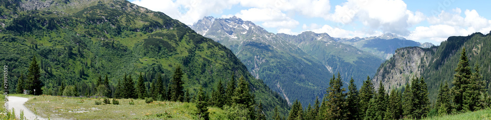 Panorama der Alpen in Vorarlberg, Österreich. Blick auf Berggipfel mit kleinen Schneefeldern, steile Felswände und ins Tal Panorama der Alpen in Vorarlberg, Österreich. Blick auf Berggipfel mit kleinen Schneefeldern, steile Felswände und ins Tal