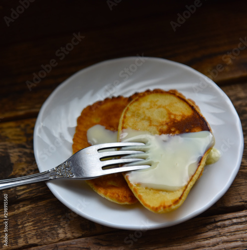pancakes with condensed milk on a wooden table
