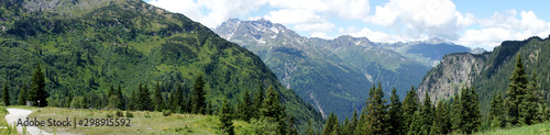 Panorama der Alpen in Vorarlberg, Österreich. Blick auf Berggipfel mit kleinen Schneefeldern, steile Felswände und ins Tal