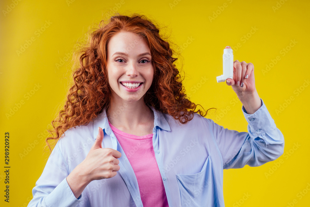 happy redhead curly ginger woman showing thumbs up pointing in studio yellow background happy redhead curly ginger woman showing thumbs up pointing in studio yellow background