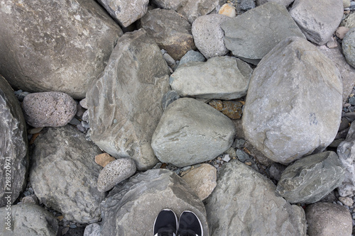 Top view black sneakers on rock at Jeongbang waterfall in Jeju Island, South Korea photo