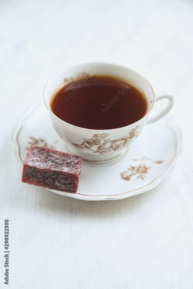 Porcelain tea pair with tea and berry marmalade on a plate Porcelain tea pair with tea and berry marmalade on a plate