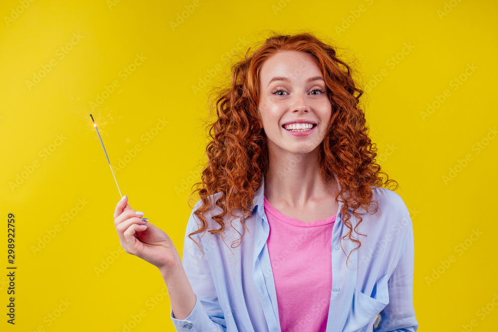 Close-up photo of cheerful caucasian girl holding bengal light with sparklers - obrazy, fototapety, plakaty 