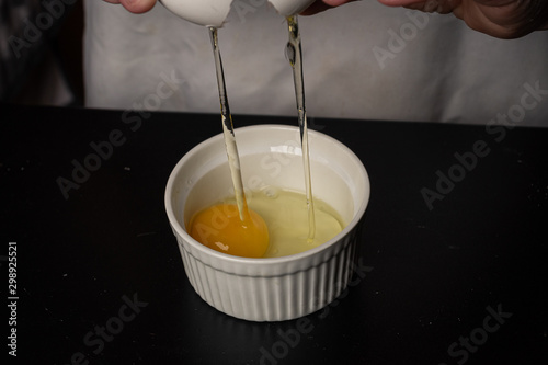 An egg being cracked into a bowl to make cookies