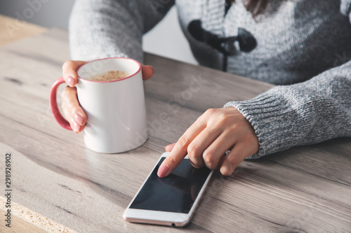 woman hand smart phone with cup of coffee