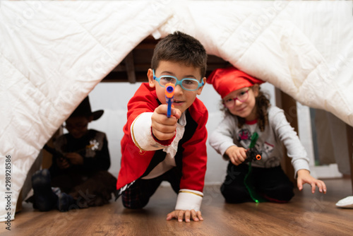 Children with in a makeshift fort play pirates and cowboys.