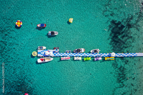 Water activities and pier on the turquoise sea water near the beach. Aerial view from above. Cyprus, Agia Napa