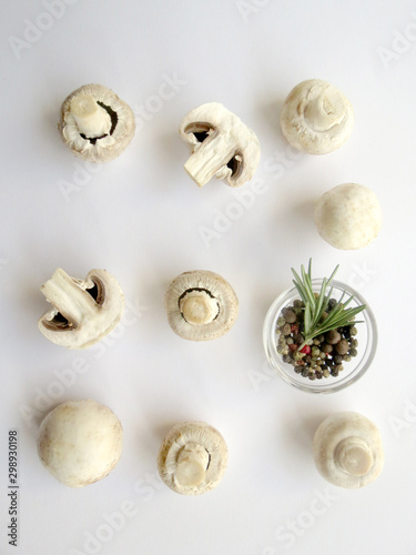Fresh champignon mushrooms with spices in bowl on white background. Vegetarian cooking. Vertical baner.