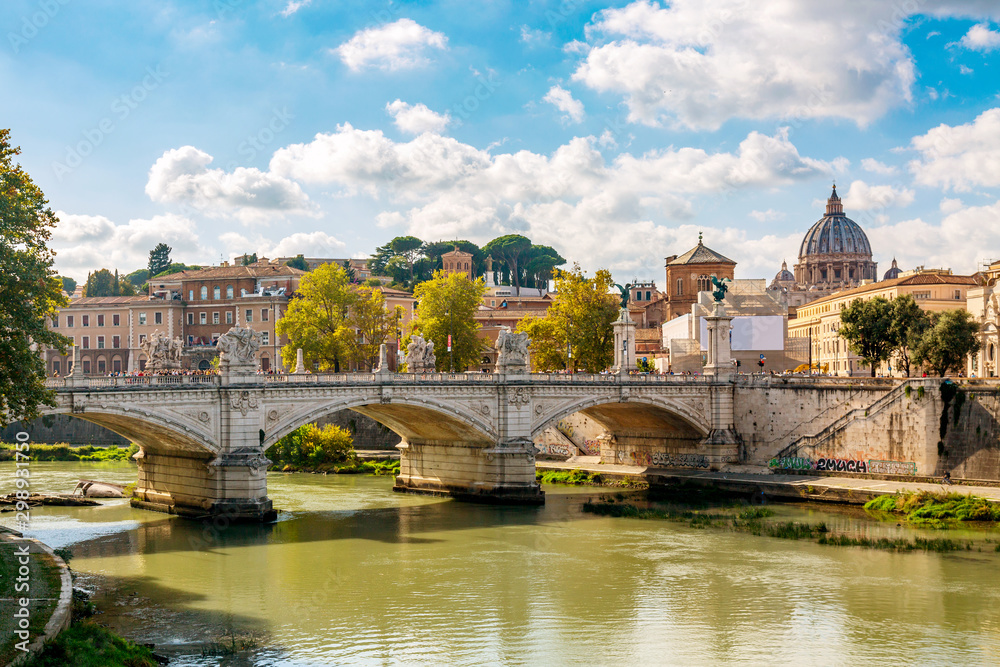 St. Peter's basilica with bridge and Tiber river in Rome during summer sunny day, Italy