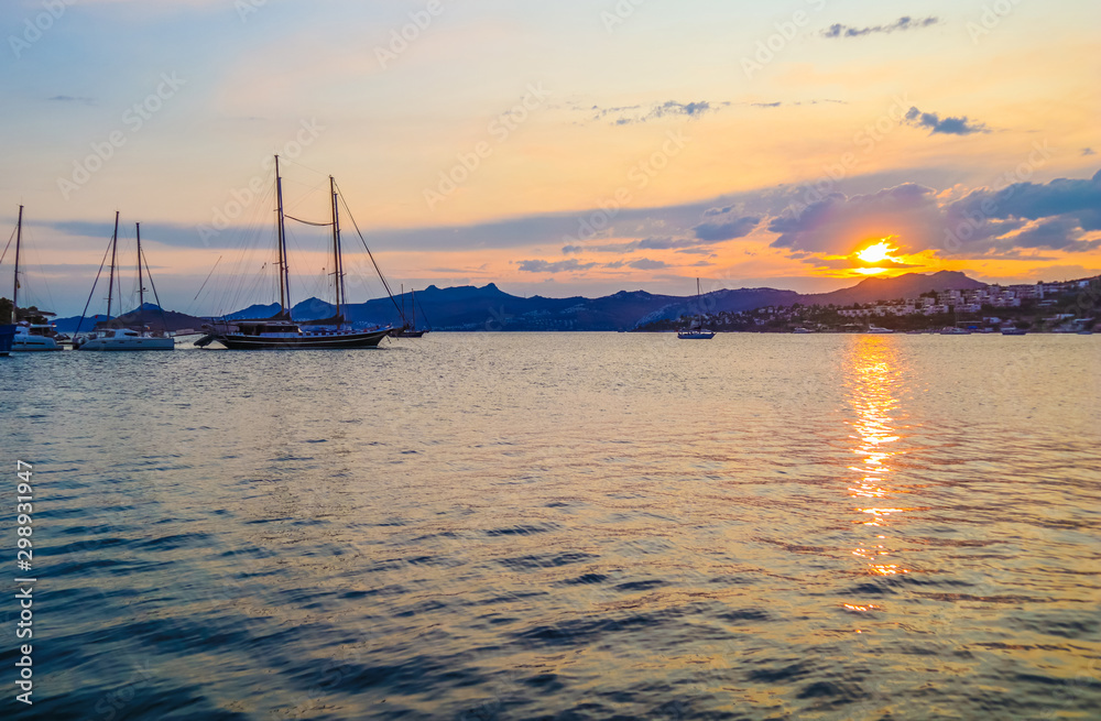 Beautiful Mediterranean coast with islands, mountains and yachts at sunset