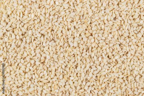 Raw white sesame seed background. Top view. Food Background. A scattering of sesame seeds. Healthy food. Natural food.